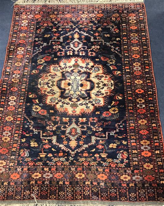 A large Persian black ground rug 170cm x 125cm